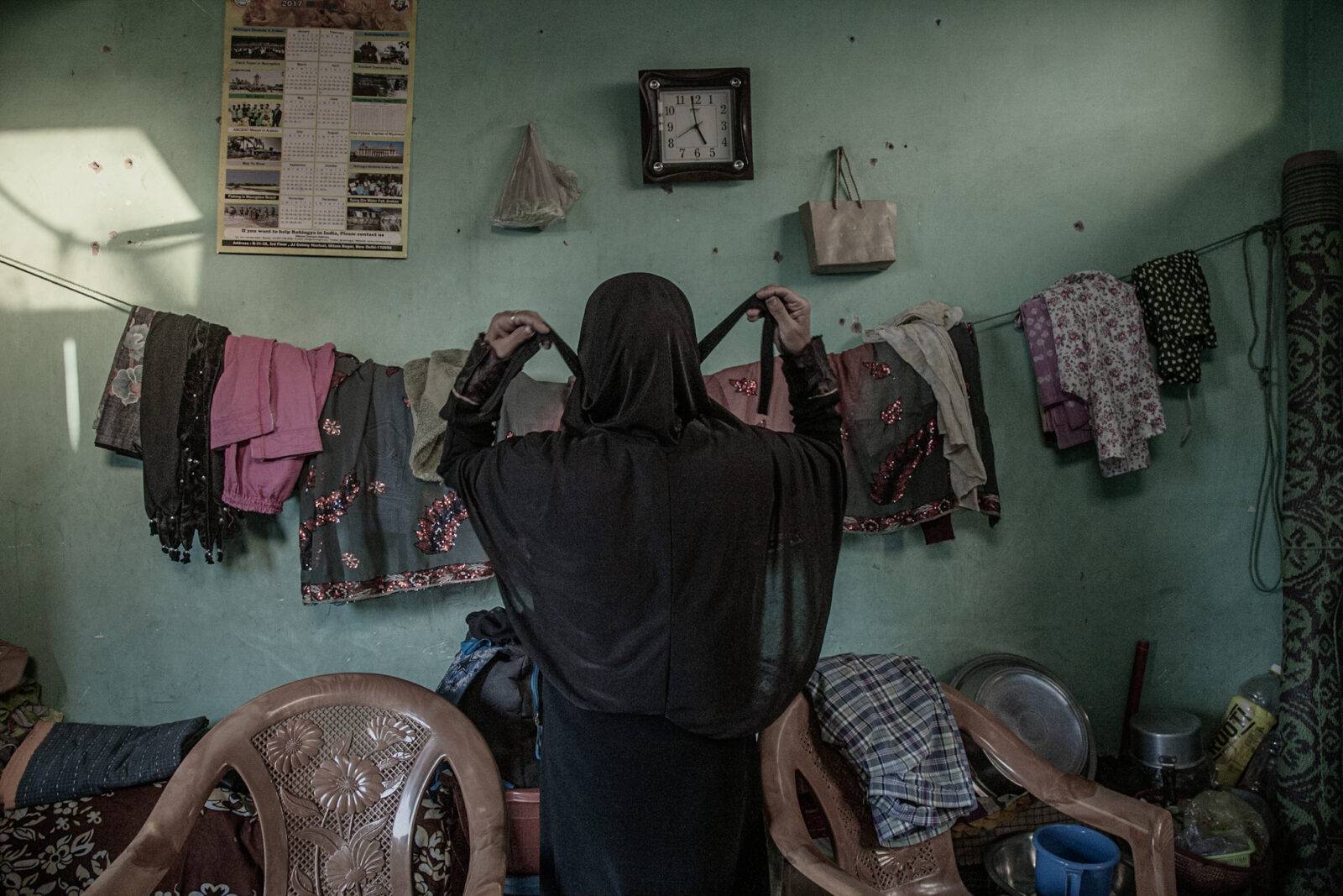 Identity card of Meena* with a family photograph, placed on a prayer rug. While her son was persecuted in the Rakhine State, she managed to escape with her daughter-in-law and grandson in 2017. *Name changed