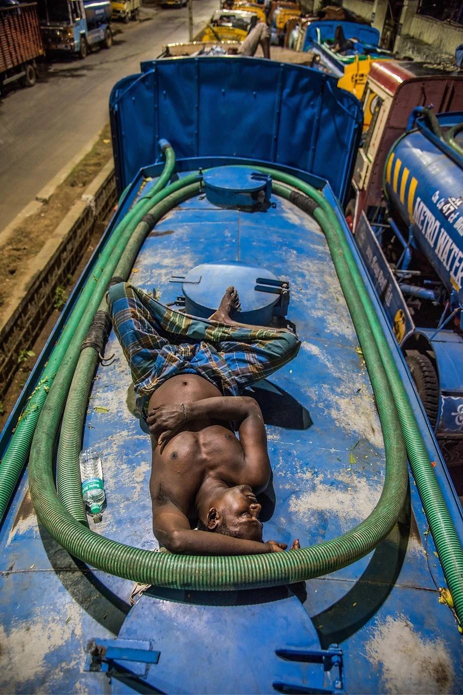 A tired driver sleeping on his water tanker in K.K.Nagar Metro water pumping station, Chennai. Photo by: Steevez Rodriguez/PEP Collective.