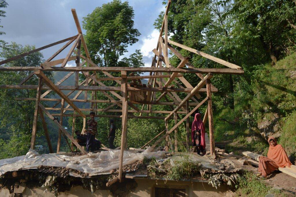 The wooden framework is erected on the roof of a traditional mud house. The line between the kutcha, pukka, and bungalow houses seems to fade in many cases, depending on affordability, site conditions, and space requirements. These hybrid house designs can be quite innovative, but sometimes precarious. Photo by Razia Akhter 